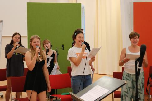 Zu sehen ist der Sopran der Young Voices Brandenburg, recht im Bild stehend Diana Labrenz, die Stimmbildnerin der Young Voices