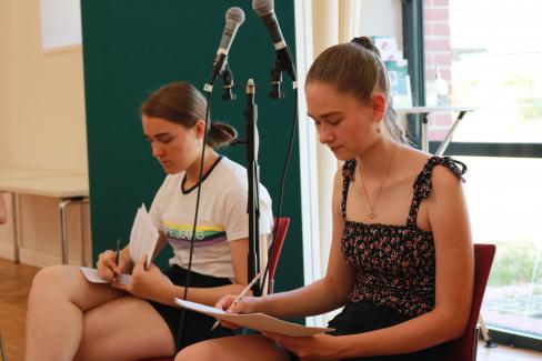 Zwei Sängerinnen der Young Voices machen sich während einer Probe Notizen in ihre Noten